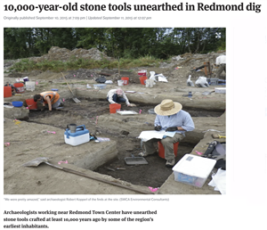 A newspaper clipping shows three people in sun hats and work clothes kneeling over a shallow rectangle carved into the dirt. There are tools and bags and buckets strewn about. The headlines says 10,000-year-old stone tools unearthed in Redmond dig.
